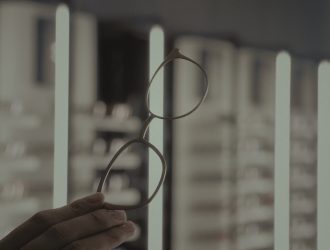 Main article image: image of a hand holding eyeglasses
