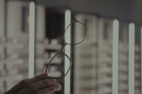 Main article image: image of a hand holding eyeglasses