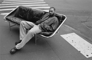 Image d'un homme assit sur un canapé dans la rue portant des vetements rag and bone