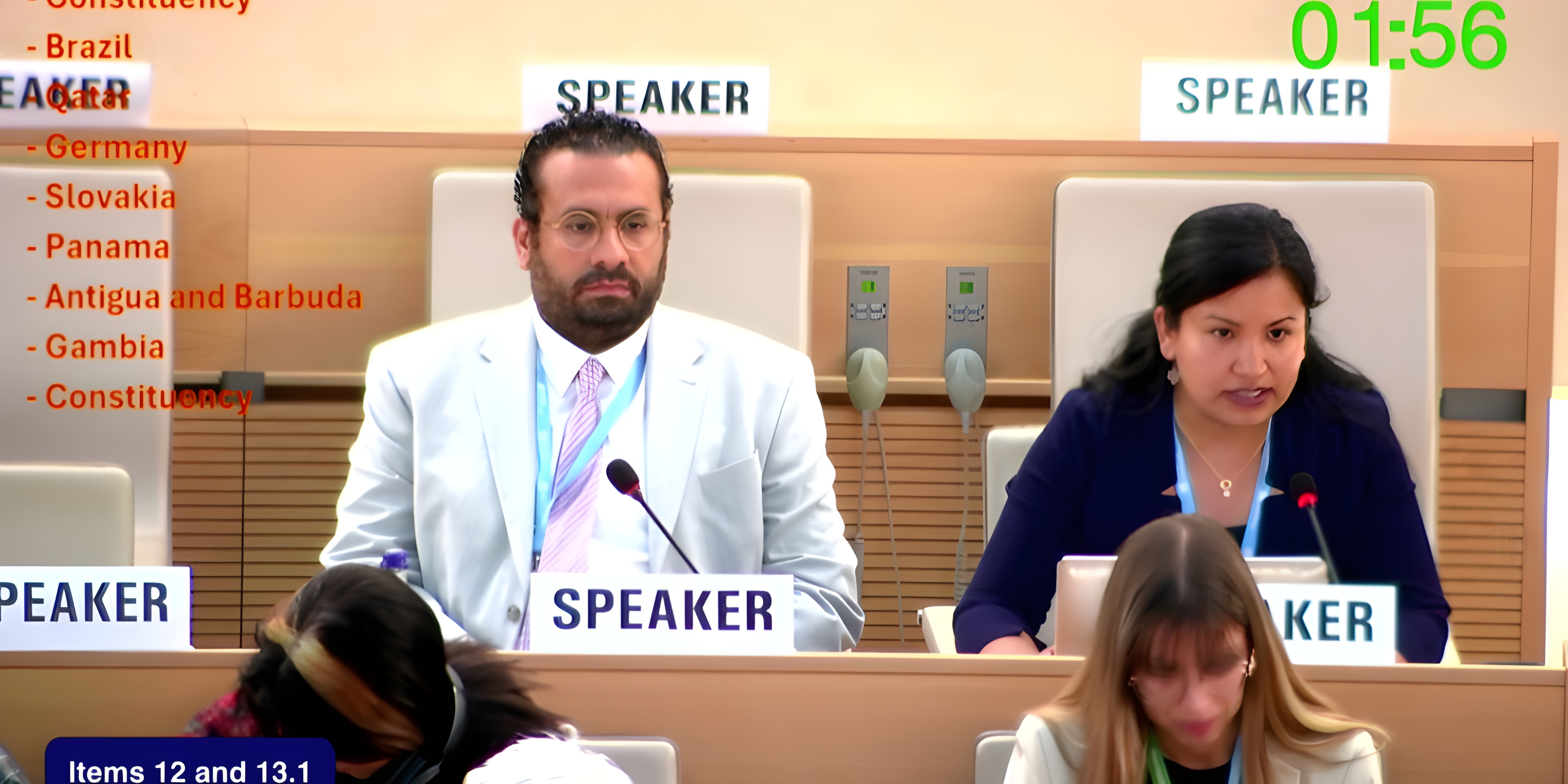 L'image montre une salle de réunion de l'Assemblée mondiale de la santé avec deux orateurs aux podiums - un homme en costume blanc et lunettes à gauche, et une femme en blazer bleu marine à droite. Le cadre est celui de la 78e Assemblée mondiale de la santé où la résolution sur les déficiences sensorielles était en discussion.