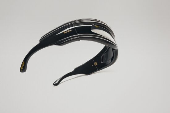 Lunettes de soleil Ray-Ban Ultra Wrap avec des montures noires courbées dramatiques et des détails rayés, flottant sur un fond blanc