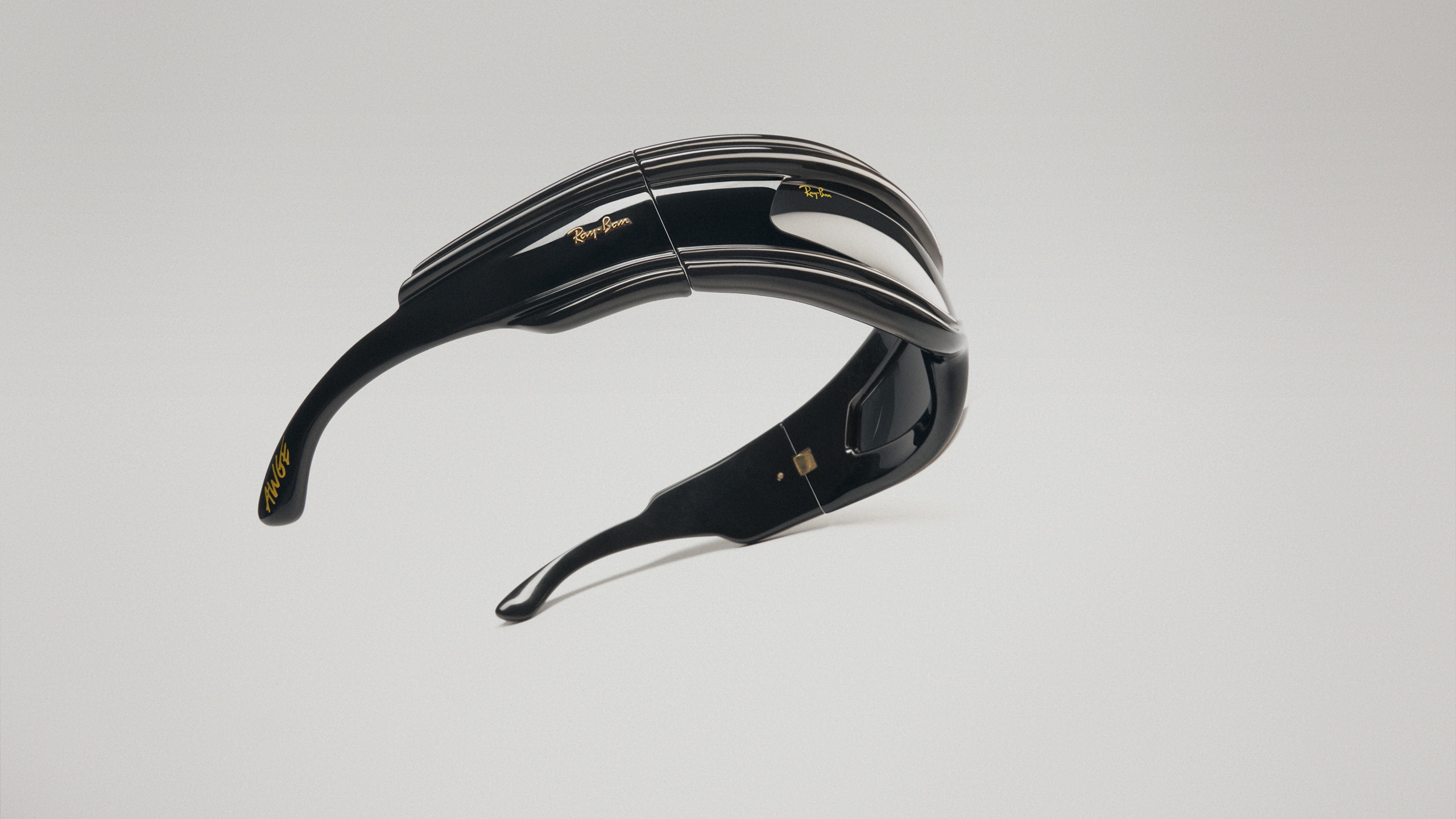 Ray-Ban Ultra Wrap 001 sunglasses with dramatic curved black frames and striped detailing, floating against a white background