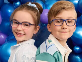Image d'un garçon et d'une fille assis sur un ballon et portant des lunettes Superflex Kids.