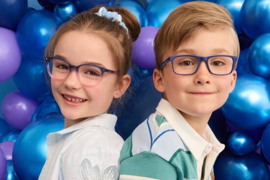 Image of a boy and a girl sitting on a baloon wearing Superflex Kids' eyeglasses