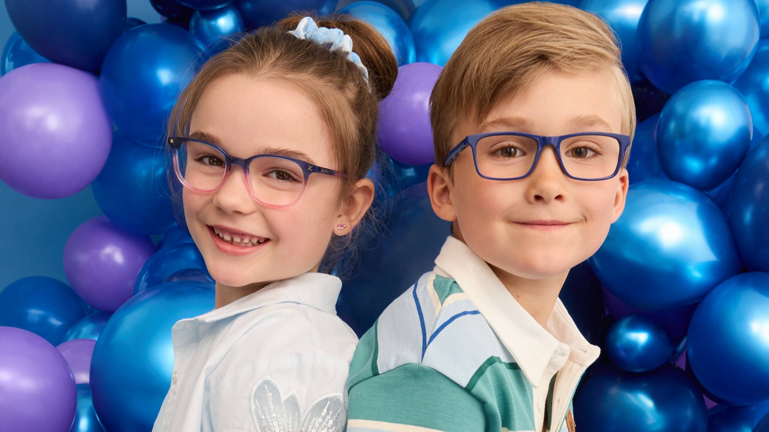 Image of a boy and a girl sitting on a baloon wearing Superflex Kids' eyeglasses