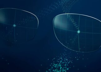 Main article image: Image of two translucent eyeglass lenses floating in a dark blue digital space, surrounded by scattered particles of light and geometric grid patterns. The image suggests a smart lens technology with a high-tech, futuristic aesthetic