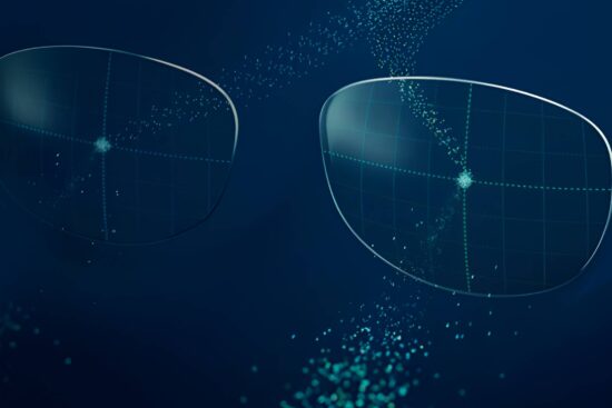 Image principale de l'article : Image de deux verres de lunettes translucides flottant dans un espace numérique bleu foncé, entourés de particules de lumière dispersées et de motifs de grille géométriques. L'image suggère des thèmes de technologie de lunettes intelligentes avec une esthétique high-tech et futuriste.
