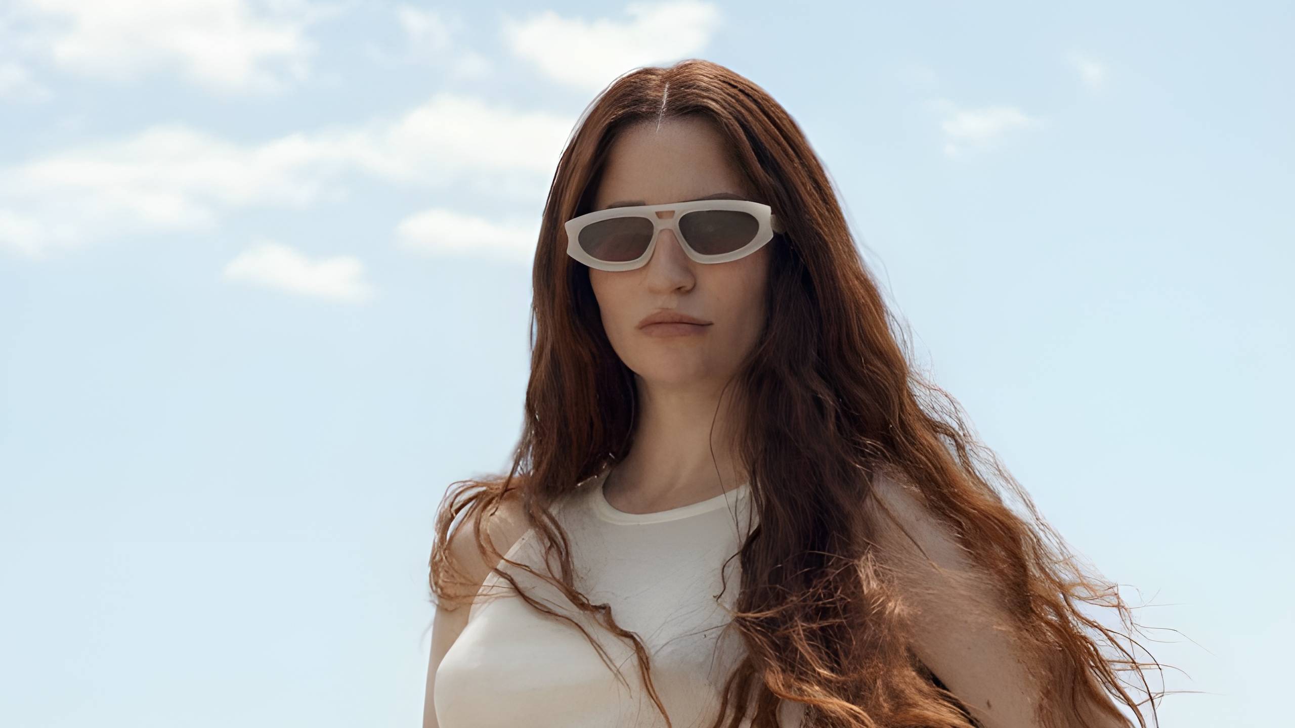 Image of a woman wearing Sediments sunglasses in a clear sky background