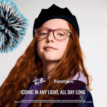 A young woman with long reddish-brown wavy hair wearing a black beret and purple-framed Ray-Ban eyeglasses with clear Transitions lenses. She has a neutral expression and is looking directly at the camera. There's a decorative spiky blue and black object visible in the upper left corner. The image includes the Ray-Ban and Transitions logos with text reading 'ICONIC IN ANY LIGHT, ALL DAY LONG' and legal text at the bottom about trademarks and licensing.