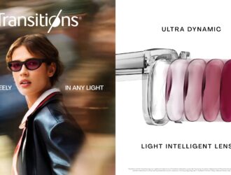 Transitions Optical marketing campaign image showing a confident woman in dark sunglasses and a navy blazer walking through a blurred urban environment. Text reads 'MOVE FREELY IN ANY LIGHT' with the Transitions logo. The right side displays 'ULTRA DYNAMIC' and 'LIGHT INTELLIGENT LENSES' with a visual demonstration of lens technology showing five progressive lens tints from clear to deep purple/magenta.