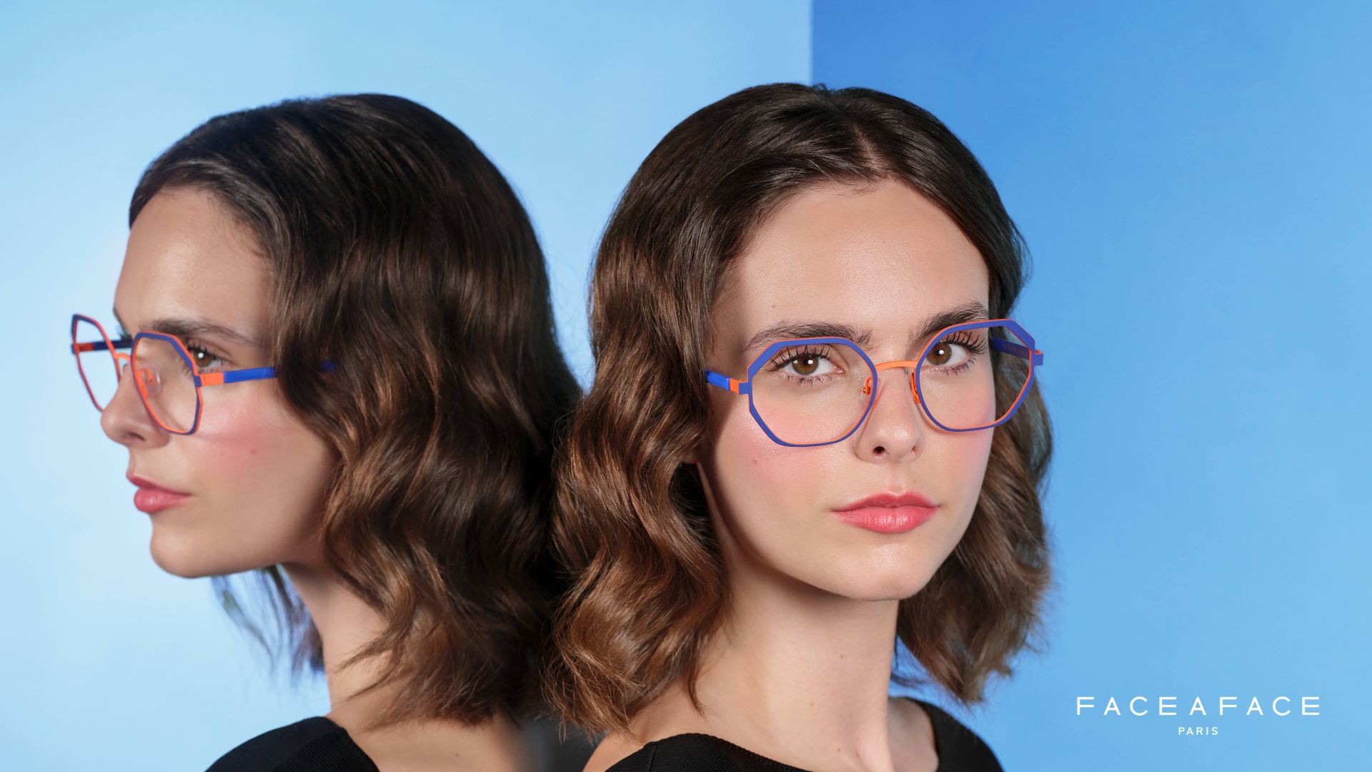 Visuel de campagne Face à Face, montrant une femme portant des lunettes géométriques colorées bleu et orange, posant à côté d’un miroir reflétant son profil sur un fond bleu dégradé.