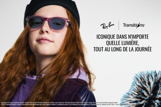 Une jeune fille aux longs cheveux roux-brun portant un béret noir et des lunettes de soleil Ray-Ban à monture violette avec des verres Transitions teintés. Elle regarde directement vers l'appareil photo avec une légère expression neutre. L'image inclut les logos Ray-Ban et Transitions avec le texte 'ICONIQUE DANS N'IMPORTE QUELLE LUMIÈRE, TOUT AU LONG DE LA JOURNÉE' et un objet décoratif épineux bleu et noir visible dans le coin inférieur droit. Du texte légal en français apparaît en bas de l'image.