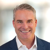 Professional headshot of Paul Lisenby, a smiling middle-aged man with gray hair wearing a dark blue blazer and white shirt