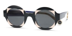 WOOW "Super Tactic" sunglasses featuring a bold geometric design with black and beige color blocking, dark gray lenses, and a distinctive angular frame shape with "Tactic" branding visible on the temple