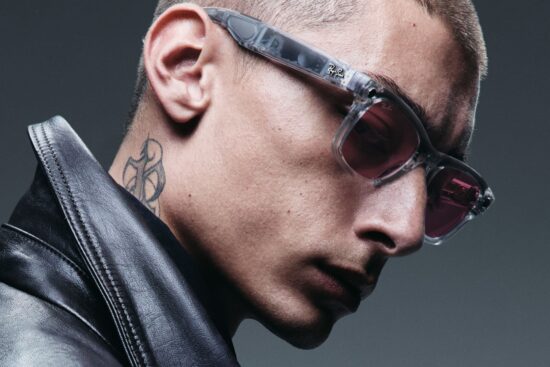 Profile view of a man wearing Ray-Ban smart glasses with tinted lenses and a black leather jacket, showcasing the stylish everyday wearability of the AI glasses