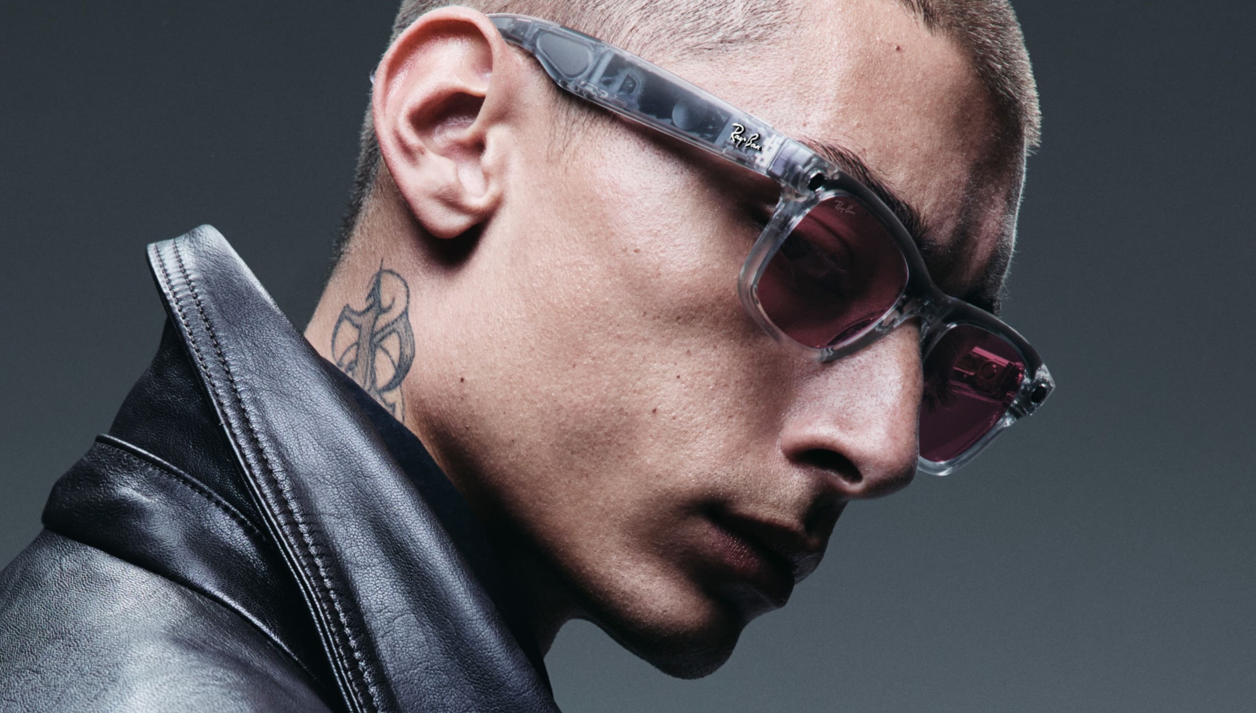 Profile view of a man wearing Ray-Ban smart glasses with tinted lenses and a black leather jacket, showcasing the stylish everyday wearability of the AI glasses