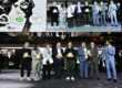 MIDO awards ceremony showing a group of award winners standing on stage holding golden trophy awards, with a large screen behind them displaying the event branding including Best Store Award, Stand Up For Green 2025, CSE Award 2025, and MIDO logos alongside images of eyewear models.