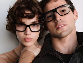 Deux jeunes personnes portant des lunettes à monture noire posant ensemble contre un fond blanc