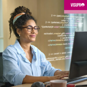 Une jeune femme noire aux cheveux bouclés sourit en regardant l'écran d'un ordinateur. Elle porte une chemise bleu clair à col et des lunettes. L'écran affiche des lignes de code et le logo stylisé de « VISUPRO » apparaît dans le coin supérieur droit.