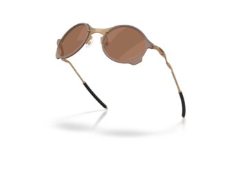 Oakley Tailend TI sunglasses in matte gold with Prizm Tungsten lenses, displayed at an angle to highlight the featherlight titanium frame.