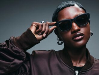 Personne portant des lunettes intelligentes Ray-Ban Meta et touchant la branche, démontrant le design élégant et la fonctionnalité mains libres des lunettes connectées à intelligence artificielle