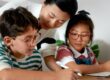 Mother helping two children with eyeglasses do homework
