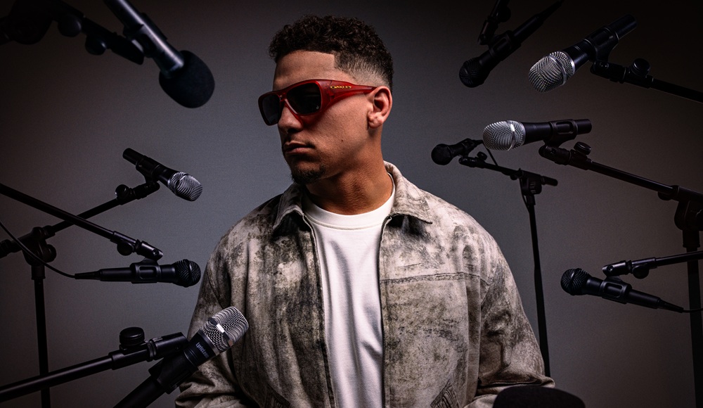 Patrick Mahomes wearing red Oakley Chaminade sunglasses in a studio setting with microphones