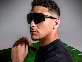 Patrick Mahomes wearing Oakley Sutro Lite Sweep sunglasses while holding a football