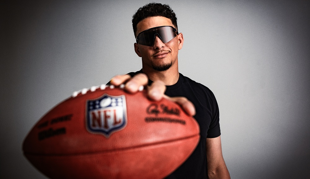 Patrick Mahomes in Oakley eyewear holding an NFL football toward the camera