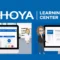 Illustration of HOYA Learning Center showing two optical professionals viewing the online training platform on computer screens, with the HOYA Learning Center logo above