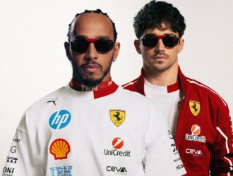 Lewis Hamilton and Charles Leclerc wearing Ray-Ban for Scuderia Ferrari Las Vegas Special Edition sunglasses with red accents, dressed in Ferrari racing suits