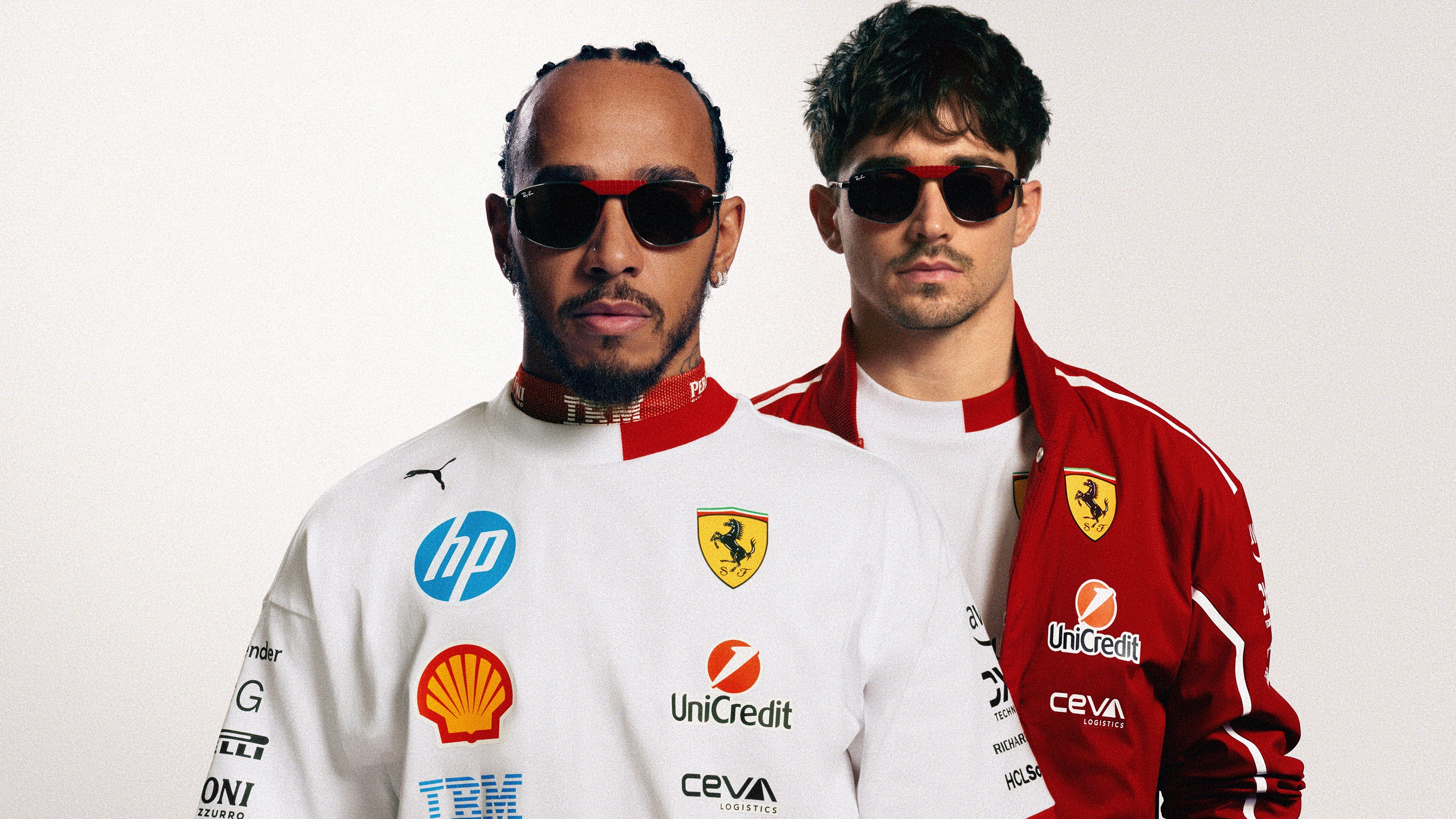 Lewis Hamilton and Charles Leclerc wearing Ray-Ban for Scuderia Ferrari Las Vegas Special Edition sunglasses with red accents, dressed in Ferrari racing suits
