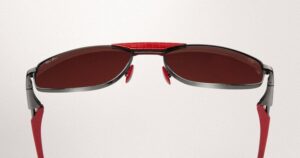 Vue arrière rapprochée des lunettes de soleil Ray-Ban pour Scuderia Ferrari montrant le détail distinctif de la barre anti-transpiration rouge sur le dessus de la monture