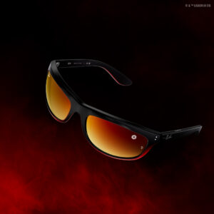Lunettes de soleil Ray-Ban Mega Balorama édition Kylo Ren en noir transparent avec verres miroir polarisés argent-rouge et insigne du Premier Ordre sur la branche, présentées sur fond dégradé noir-rouge