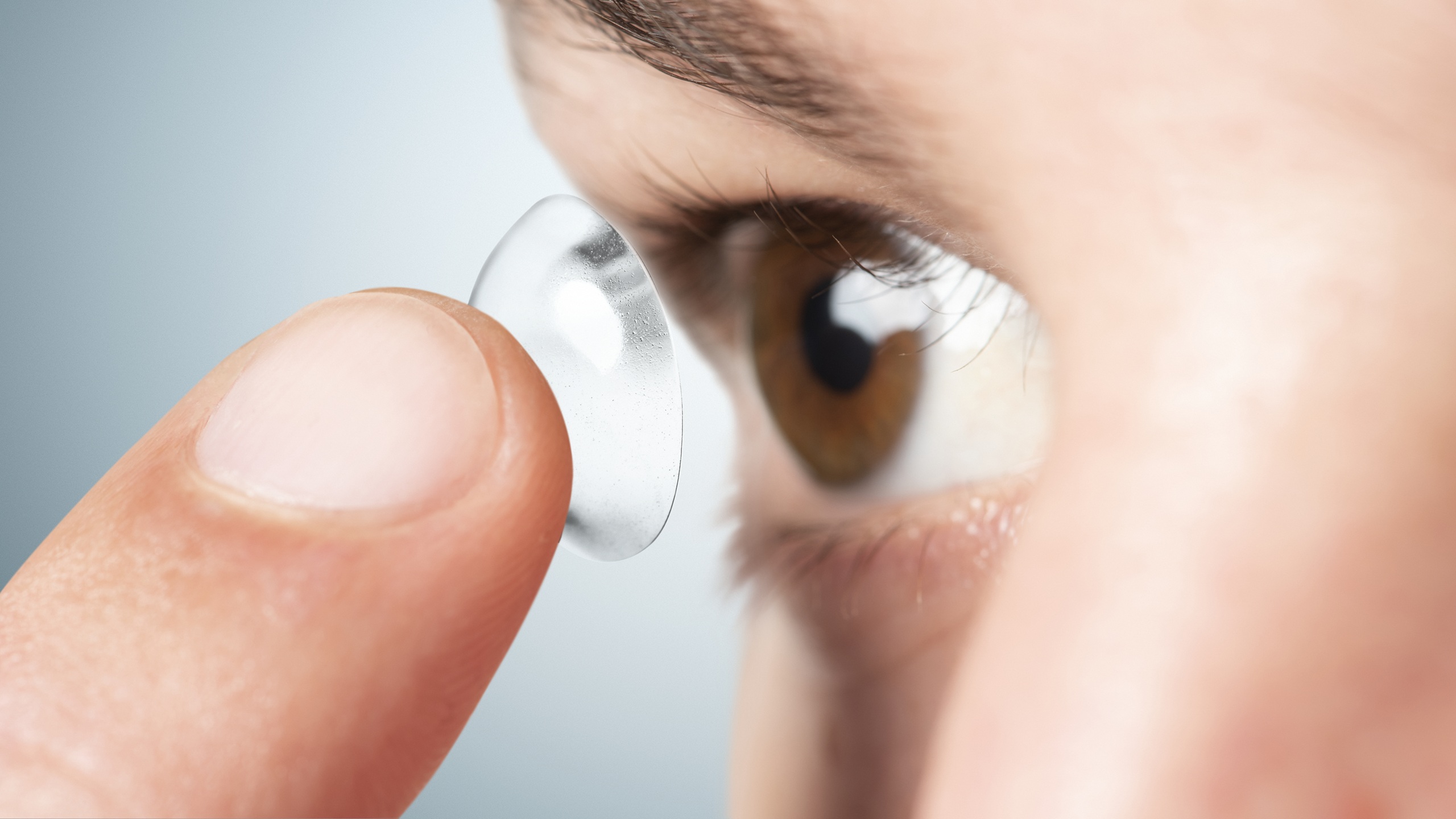 Person about to apply a contact lens for vision correction