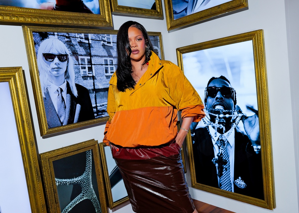 Rihana e explorant un mur de galerie présentant des photographies encadrées d'or de lunettes Ray-Ban et d'icônes culturelles