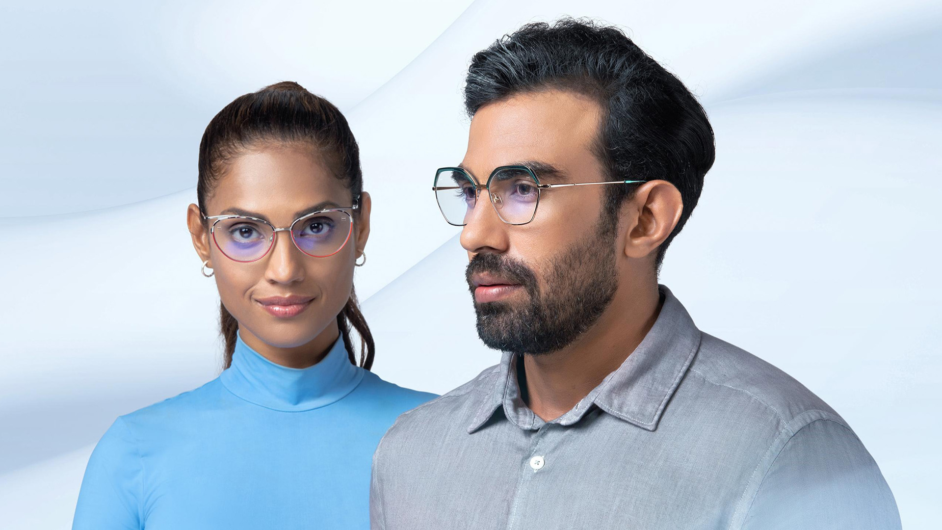Femme et homme portant des lunettes progressives ZEISS modernes avec verres filtrant la lumière bleue sur fond blanc épuré