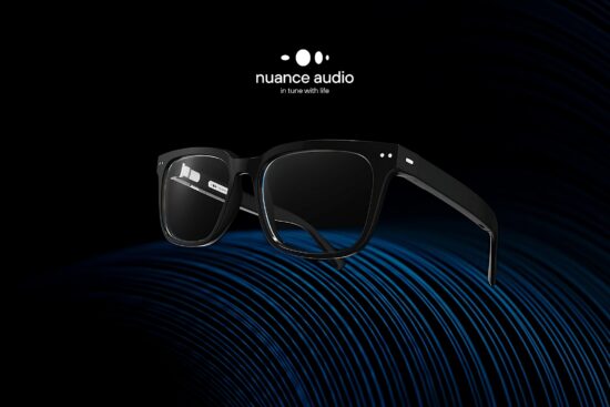 Nuance Audio hearing aid glasses in black frame displayed on blue acoustic soundwave surface against dark background