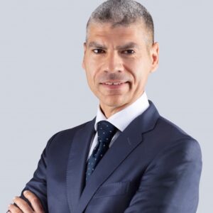 Professional headshot of Nicola Zotta in a navy suit with arms crossed
