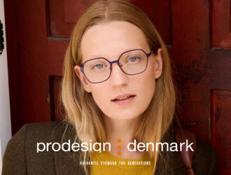 A woman wearing thin blue and orange ProDesign frames from the 2026 collection.