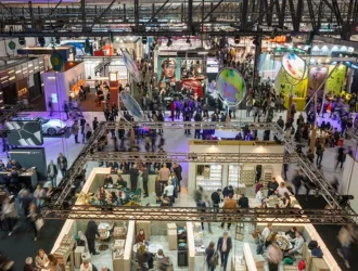 Aerial view of MIDO 2026 exhibition floor with colorful booths and crowds of visitors