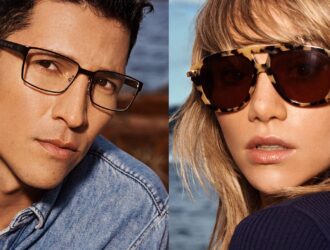 A split-screen portrait featuring Danny Ramirez in clear-lens optical glasses and Suki Waterhouse in oversized tortoiseshell sunglasses against a coastal background