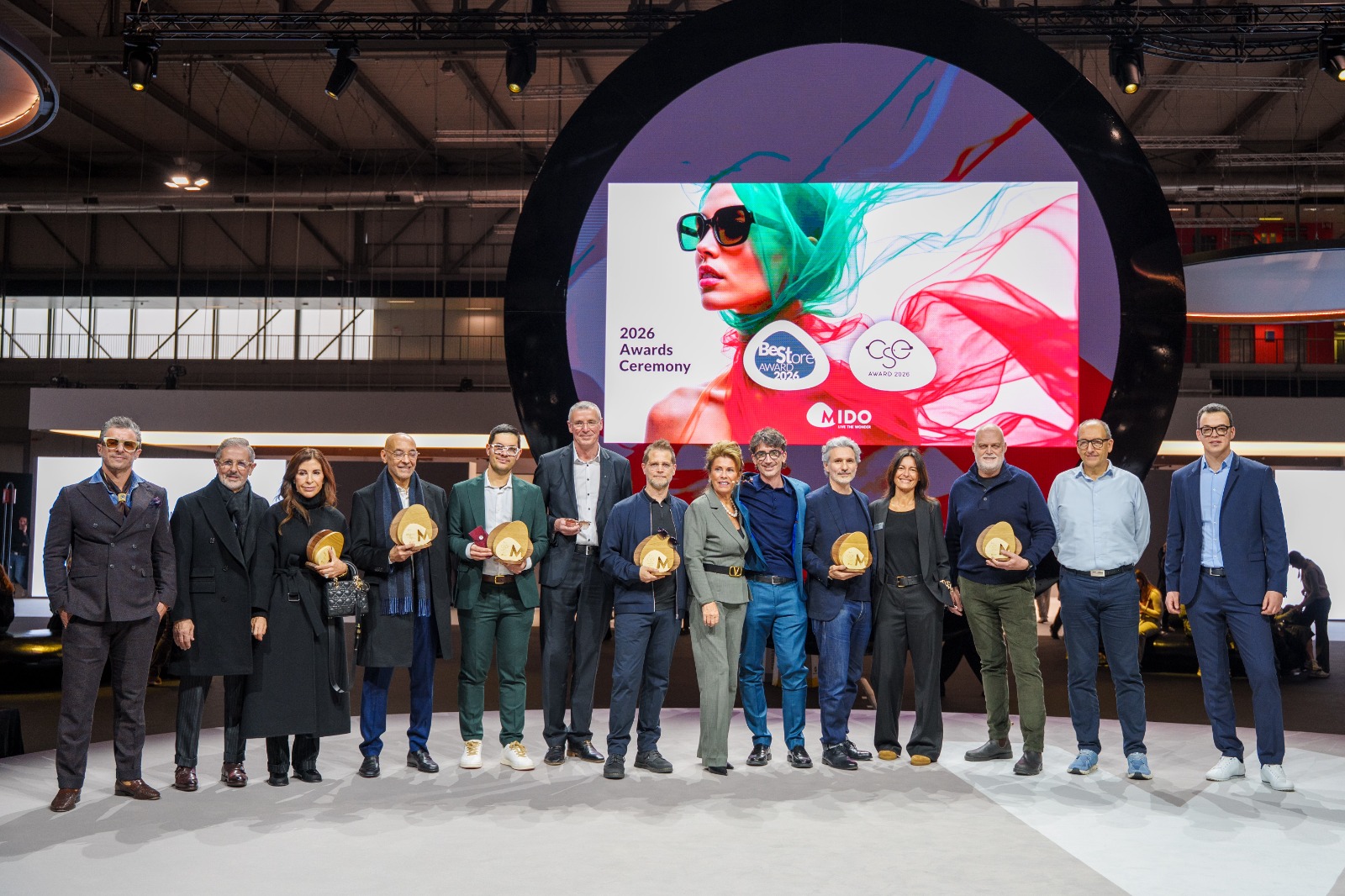 Les lauréats des MIDO Awards 2026 posent avec la Présidente de MIDO et ANFAO, Lorraine Berton, sur scène en tenant leurs récompenses devant le décor de la cérémonie des Awards 2026