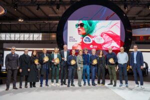 MIDO Awards 2026 winners pose with President of MIDO and ANFAO, Lorraine Berton, on stage holding their awards in front of the 2026 Awards Ceremony backdrop