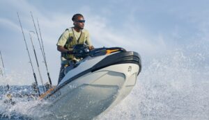 Emmanuel Williams piloting a personal watercraft through ocean spray, wearing the protective Pilothouse PRO eyewear.