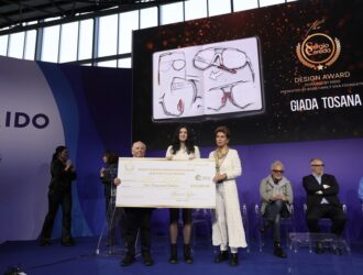 Giada Tosana tenant un chèque de 10 000 $ pour le Grand Prix du Sergio Cereda Eyewear Design Award 2026 sur la scène du MIDO.