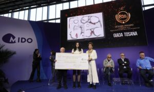 Giada Tosana tenant un chèque de 10 000 $ pour le Grand Prix du Sergio Cereda Eyewear Design Award 2026 sur la scène du MIDO.