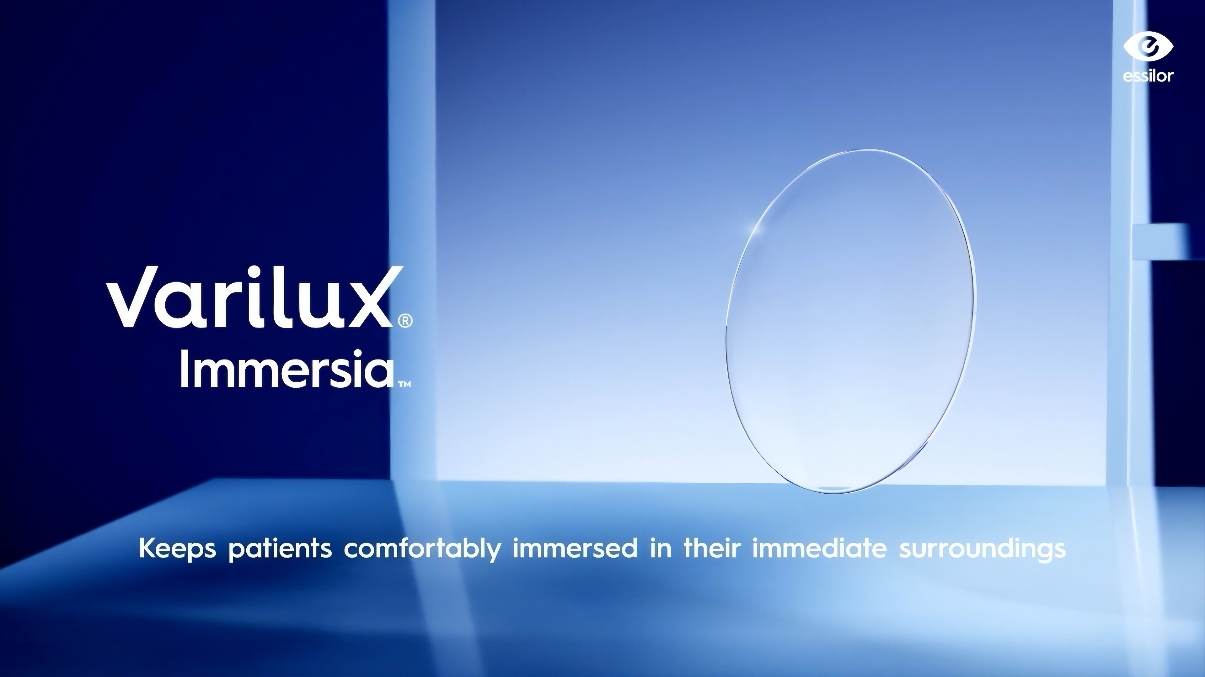 Un verre de lunettes Varilux Immersia flottant avec un motif hexagonal bleu, sur un fond minimaliste bleu avec le logo Essilor en haut à droite.