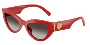 Dolce&Gabbana DG4536 cat-eye sunglasses in bold red acetate with grey gradient lenses, featuring a dramatic angular silhouette, gold-toned Sacred Heart temple detail, and gold metal hinge accent. Three-quarter product view on white background.