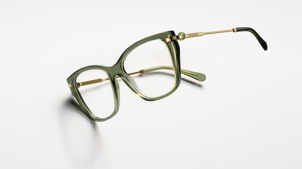 Montures optiques Swarovski SS26 en acétate vert avec quincaillerie dorée et détail de charnière en cristal